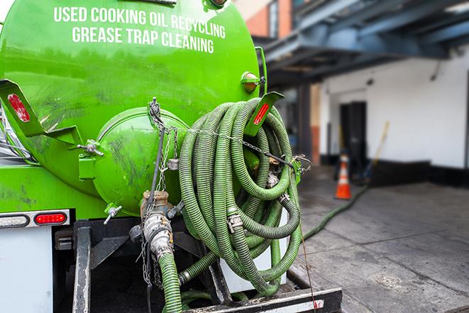 a grease trap pumping truck at a restaurant in Almont MI